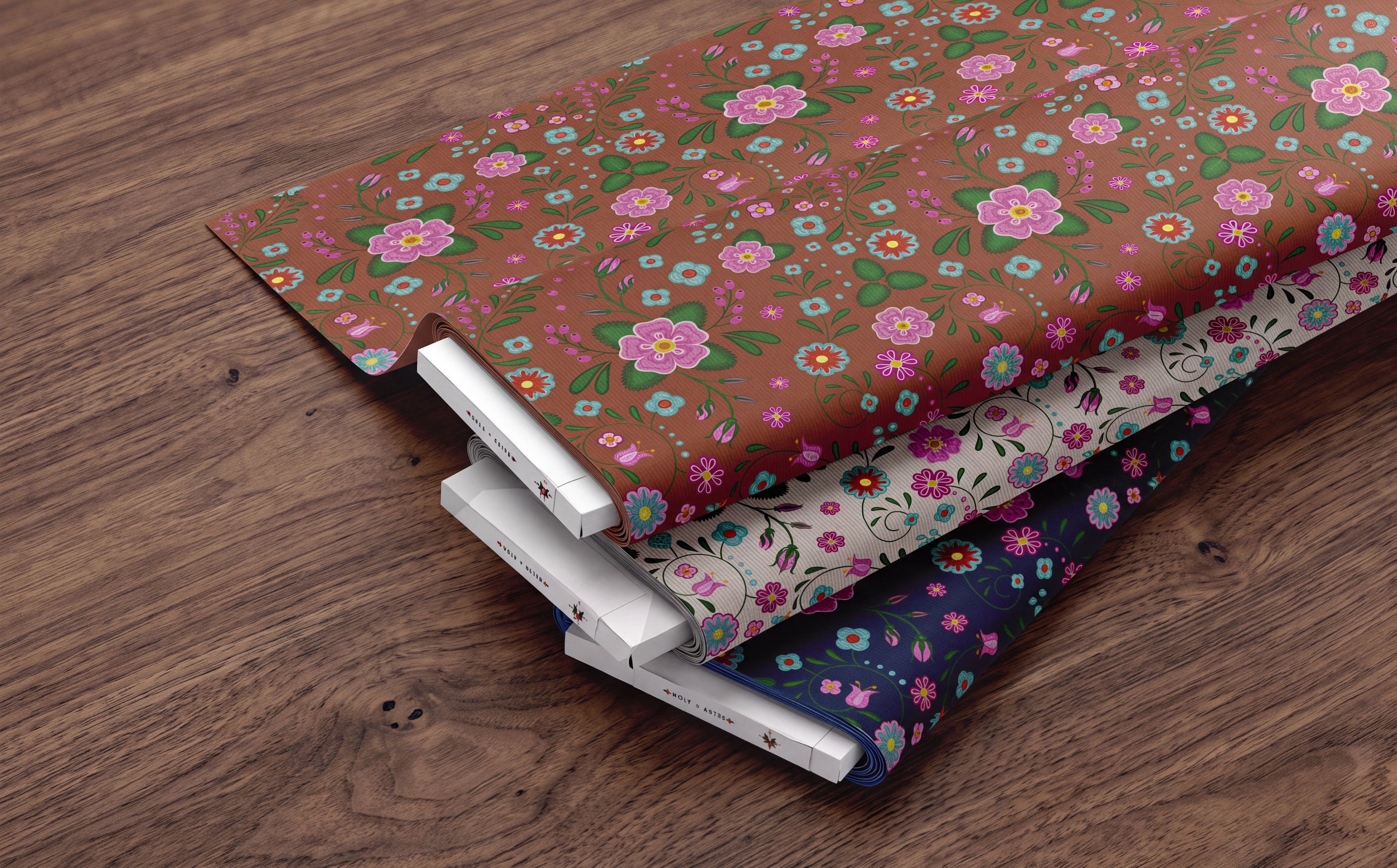 Alberta Floral Fabric Collection with three colourways on a wooden table.